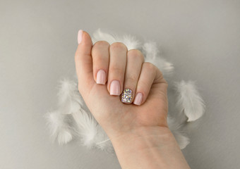 Stylish fashionable women pink manicure with feathers