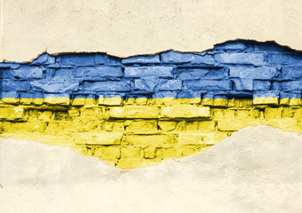 National flag of Ukraine on a brick background. Brick wall with partially destroyed plaster, background or texture.