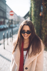 young beautiful stylish woman walking in pink coat