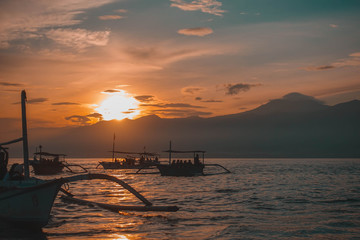 Fototapeta na wymiar Traditional balinese fisherman's boats on sunrise in the ocean, Lovina, north of Bali, Indonesia