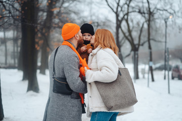 Fototapeta na wymiar Dad mom and baby in the park in winter