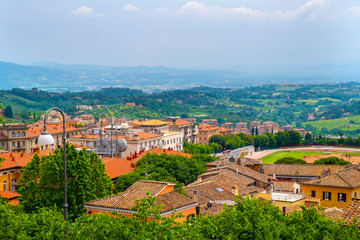 Fototapeta na wymiar Perugia, Italy - Panoramic view of the Perugia historic quarter with medieval houses and Umbria valleys and mountains in background