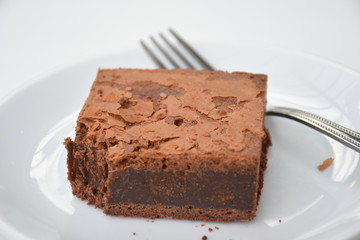 四角いチョコレートブラウニーと、後ろにフォーク