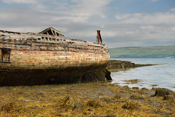 Shipwreck on Salen beach with seaweed at low tide on Sound of Mull Isle of Mull Scotland UK