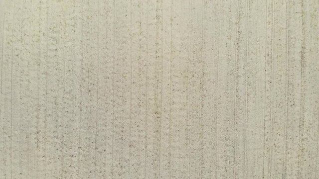 Aerial top down view. Crop agricultural fields. Rows of soil before planting, ploughed field, spring or autumn season landscape. Nature background, farm pattern