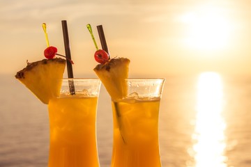 Yellow luxury summer sun cocktail at sea sunset tourism paradise. Fresh cool juicy orange pineapple coktails. Perfect wellness drink for enjoyment and relaxation at holiday cruise or vacation travel