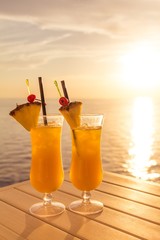 Yellow luxury summer sun cocktail at tourism sea sunset paradise. Fresh cool juicy orange pineapple...