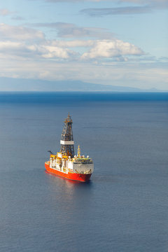 offshore oil and gas drillship, blue sea background, aerial view