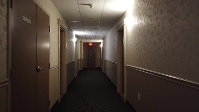 Walking Down Building Hotel Hallway Corridor Towards Exit Sign