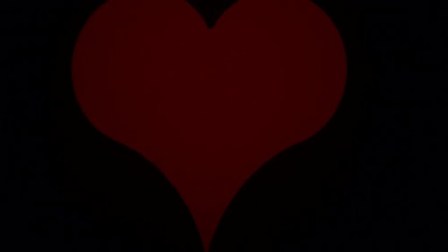 Romantic red heart shape sign on dark black wall. Love, valentines day