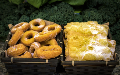 Rosquillas y orejas postres típicos gallegos de carnaval cubiertos de azúcar en fondo verde