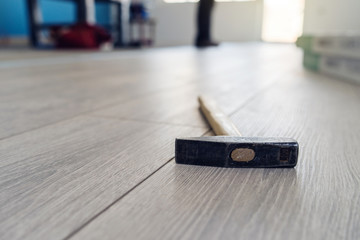 Close up on hammer tool on the wooden laminate floor