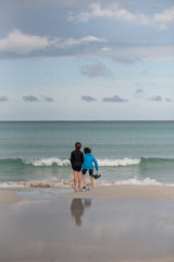 coppia di bambini, giocano in riva al mare con le onde