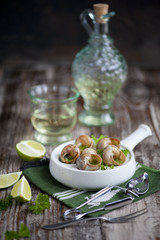 Escargots de Bourgogne on a plate on wooden Background
