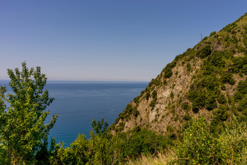 Fototapeta na wymiar Italy, Cinque Terre, Corniglia, a close up of a hillside next to a body of water