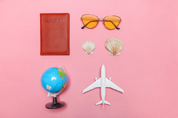 Obraz premium Vacation travel summer weekend sea adventure trip concept. Minimal simple flat lay with plane passport sunglasses globe and shell on pink pastel trendy modern background