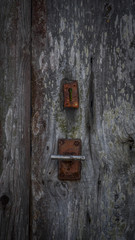 Cerradura antigua oxidada vintage en puerta de madera centenaria.