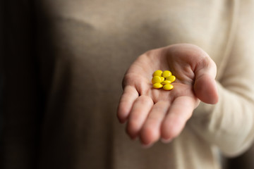 Colorful pills and drugs in hand on a dark background. Medicine and treatment