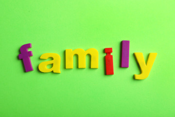 Word FAMILY of magnetic letters on color background, top view