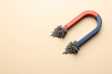 Magnet with iron powder on color background, top view. Space for text