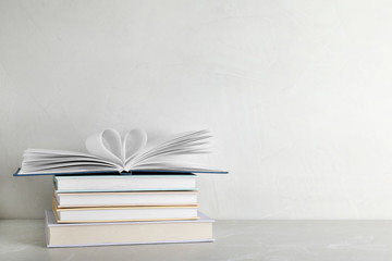 Stack of hardcover books on table against white background, space for text