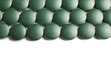 Spirulina tablets on white background, top view