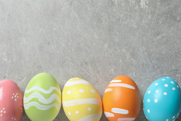 Flat lay composition of painted Easter eggs on color background, space for text
