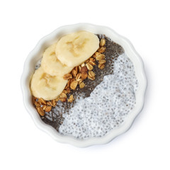 Bowl of tasty chia seed pudding with granola and banana on white background, top view