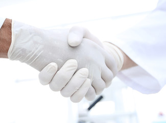 Handshake with white medical gloves