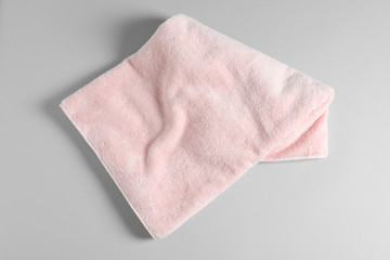 Soft folded towel on light background, top view