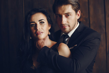 Elegant man in a black suit. Couple at home. Hot woman in a black underwear