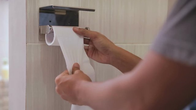 Close up of a person hand using toilet paper