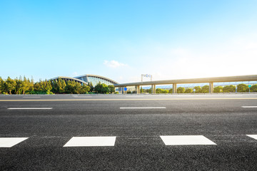 Fototapeta premium Empty asphalt road and railway station buildings in Shanghai
