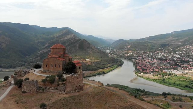 Aerial drone panoramic view of Georgian Orthodox Church Jvari, beautiful view of mountains, river and Mtskheta ancient city.