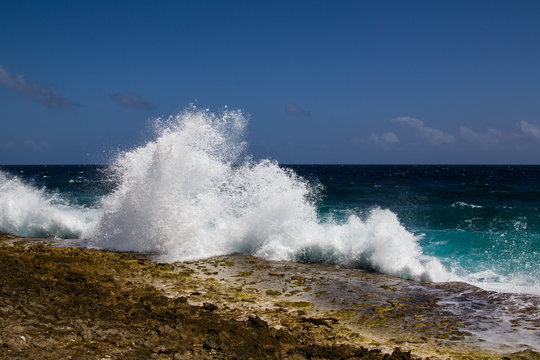Wild and high waves breaking at the rough shoreline of the west coast of the island of Bonaire