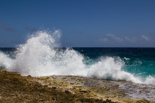 Wild and high waves breaking at the rough shoreline of the east coast of the island of Bonaire
