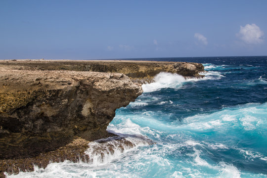Wild and high waves breaking at the rough cliffs on the east coast of the tropical island of Bonaire in the caribbean