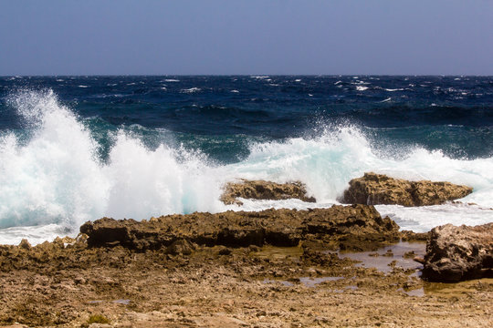 Wild and high waves breaking at the rough shoreline of the Caribbean east coast of the Caribbean island of Bonaire