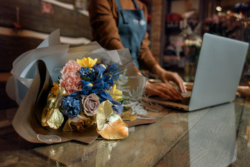 Flower's business. Family flowers business. Work at the computer in the lifestyle flower shop. Beautiful  bouquet of flowers. Detail. Close up.