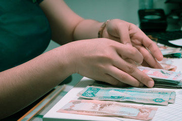 Female person counting money on the table
