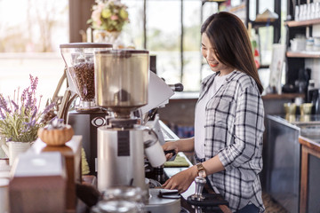 woman preparing coffee with machine in cafe