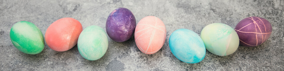 Bunt gefärbte Ostereier auf Tisch in grau, Panorama, Konzept Ostern