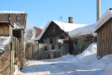 old wooden village house with outbuildings in the winter in Russia