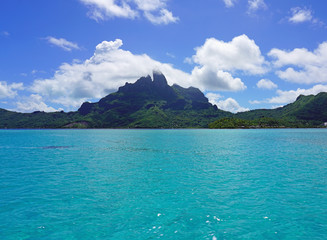 Landscape view of the island of Bora Bora in French Polynesia with the Mont Otemanu mountain surrounded by a turquoise lagoon