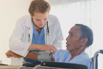 Obraz premium The doctor is checking the elderly sitting on the cart.