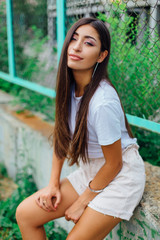 Portrait of a swag girl sitting next to rabitz fence