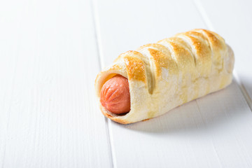 Classic fresh homemade sausage in batter on a white wooden table.