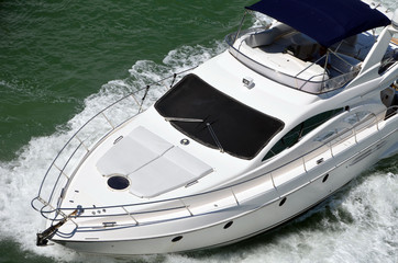 Close-up angled overhead view of a small white motor yacht  cruising the Florida Intra-Coastal...
