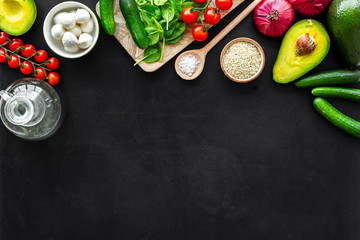 Ingredients for fresh vegetable salad on black kitchen desk top view copy space