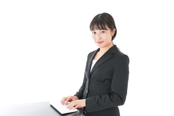 立ってデスクワークをする若いビジネスウーマン